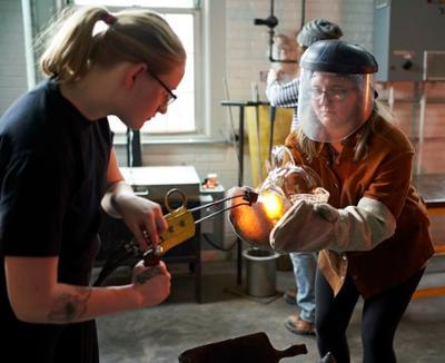 students working together with blown glass